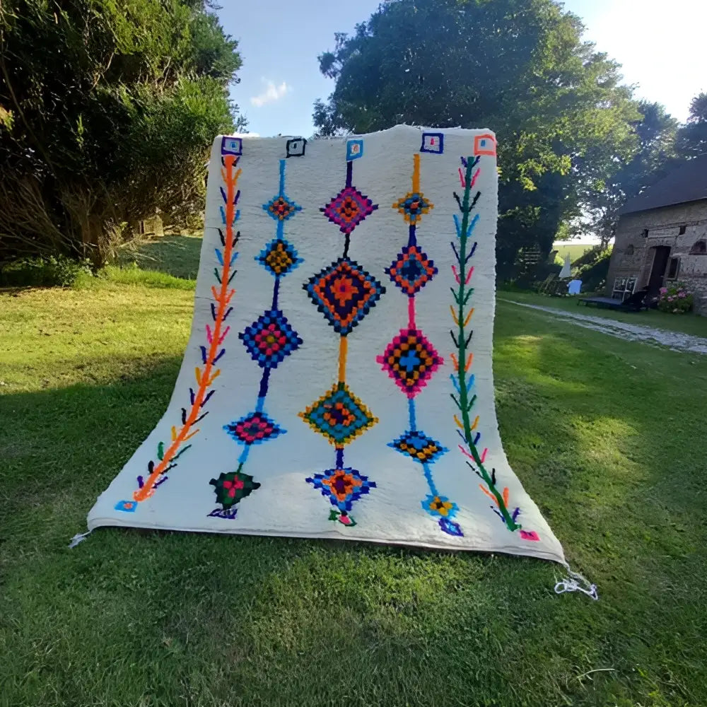 A vibrant moroccan handmade azilal rug by decorbites with cream base and bold multicolored geometric patterns 2.5m x 1.5m