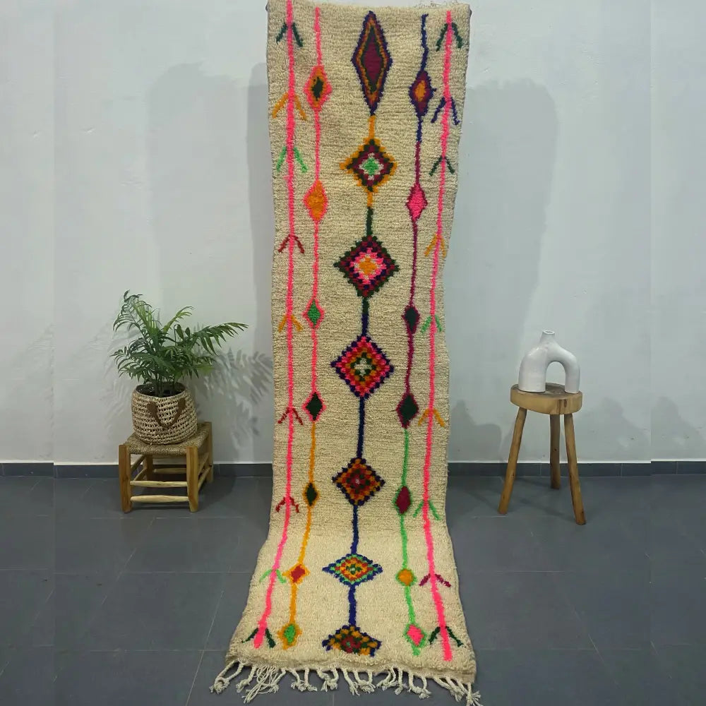 A vibrant cream-colored moroccan handmade azilal rug with bold geometric patterns and textured woolen surface by decorbites
