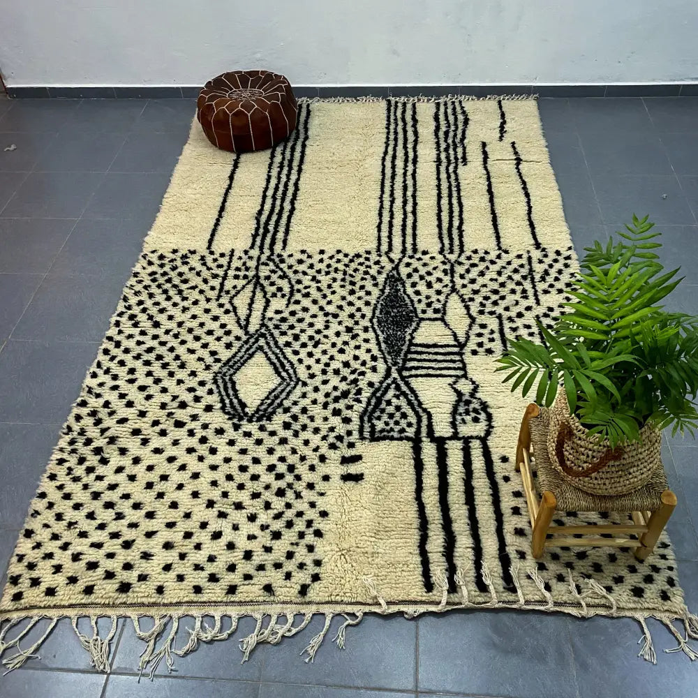 Cream-colored moroccan handmade azilal rug with bold black geometric patterns and fringed edges by decorbites 3m x 2m