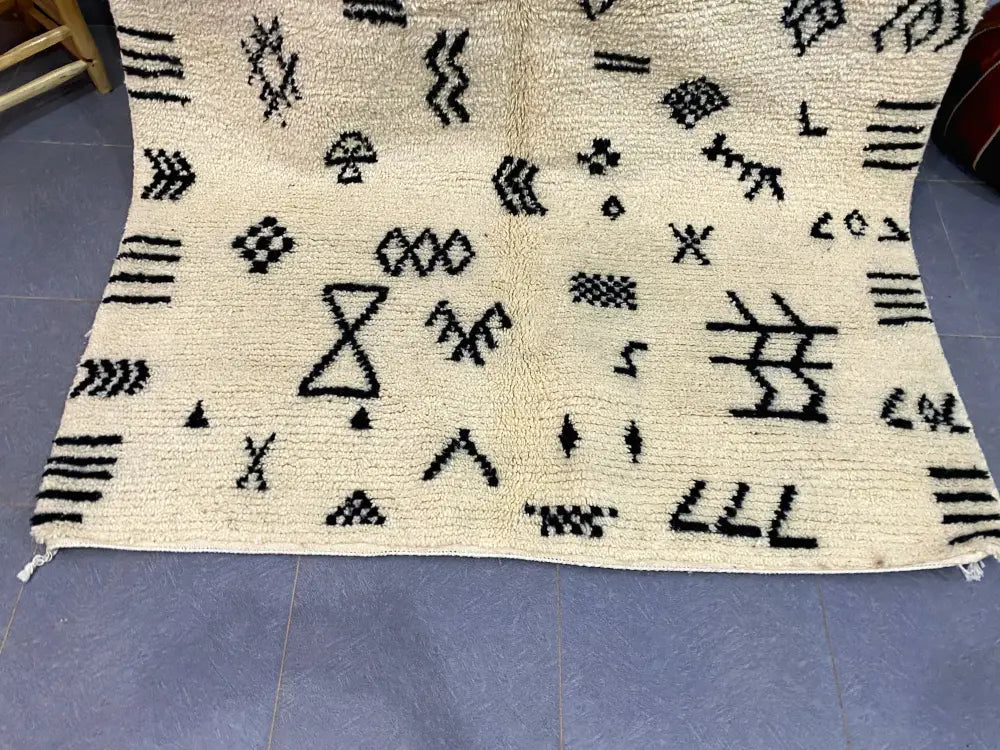 Cream-colored moroccan handmade beni ouarain rug with intricate black geometric patterns 2.5m x 1.5m by decorbites