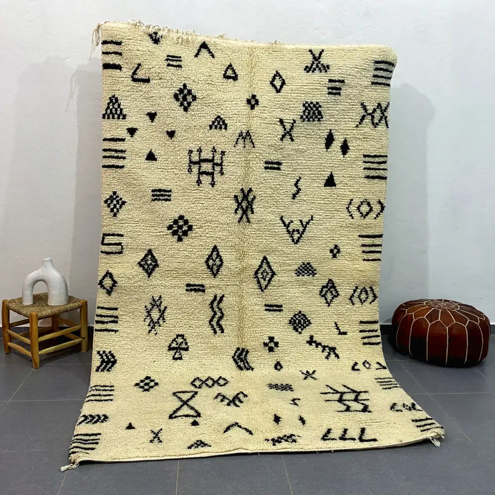 Cream-colored moroccan handmade beni ouarain rug with black geometric patterns and fringed edges 2.5m x 1.5m