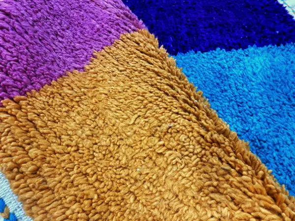 A plush multicolored shag rug with purple royal blue and golden brown hues moroccan handmade beni ouarain decorbites