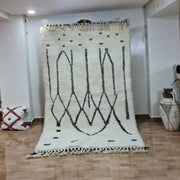 Cream-colored moroccan handmade beni ouarain rug with black geometric patterns and fringed edges 2.5m x 1.5m