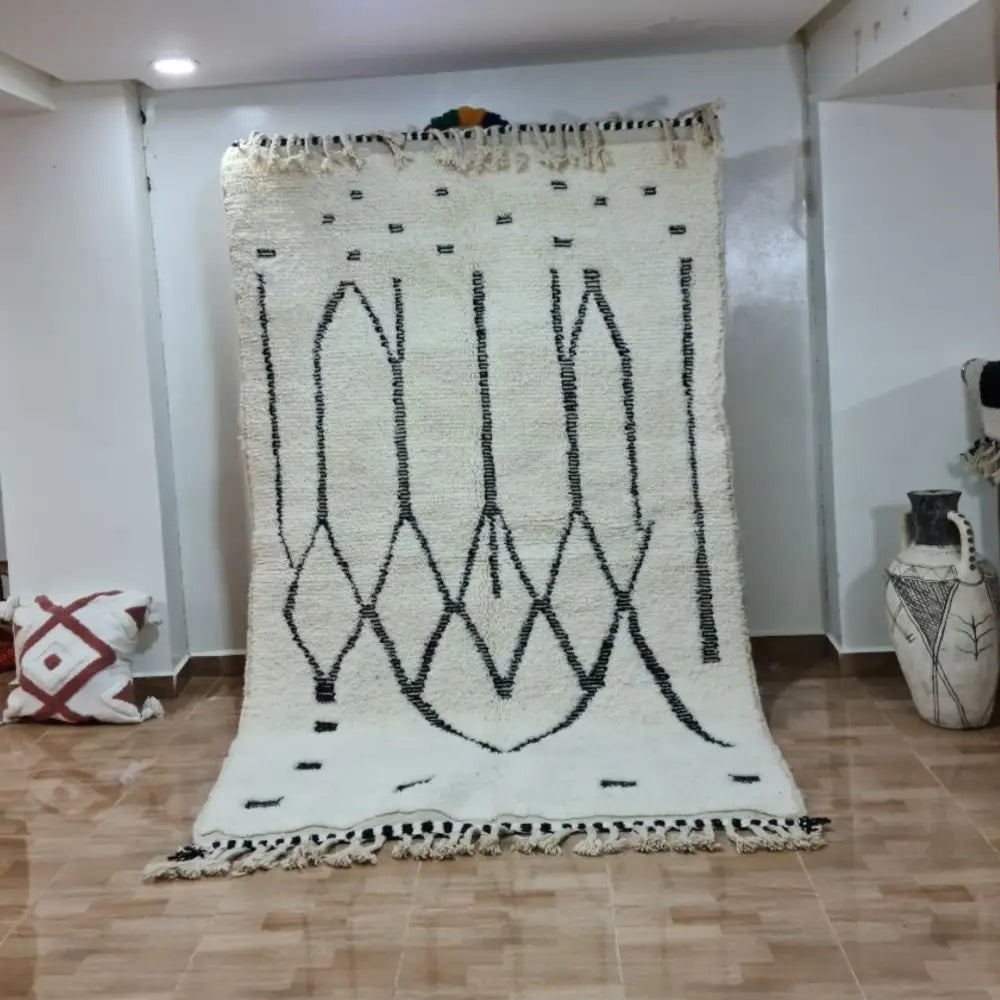 Cream-colored moroccan handmade beni ouarain rug with black geometric patterns and fringed edges 2.5m x 1.5m