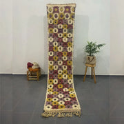 A long moroccan handmade beni ouarain rug with geometric patterns in beige mustard yellow and deep burgundy tones