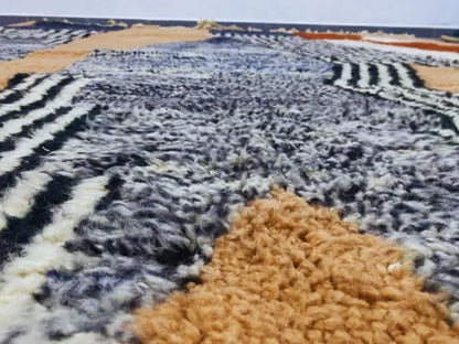 A plush moroccan handmade beni ouarain rug with bold gray black white and tan geometric stripes by decorbites