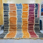 Decorbites™ moroccan handmade beni ouarain wool rug with vibrant blue orange purple and red stripes on cream background