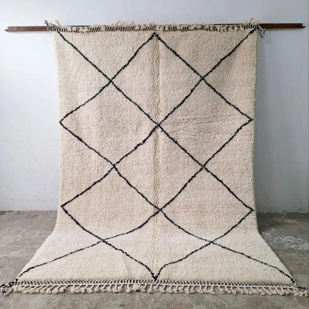 Cream-colored beni ouarain rugs with bold black geometric diamond pattern and fringed edges moroccan handmade decorbites