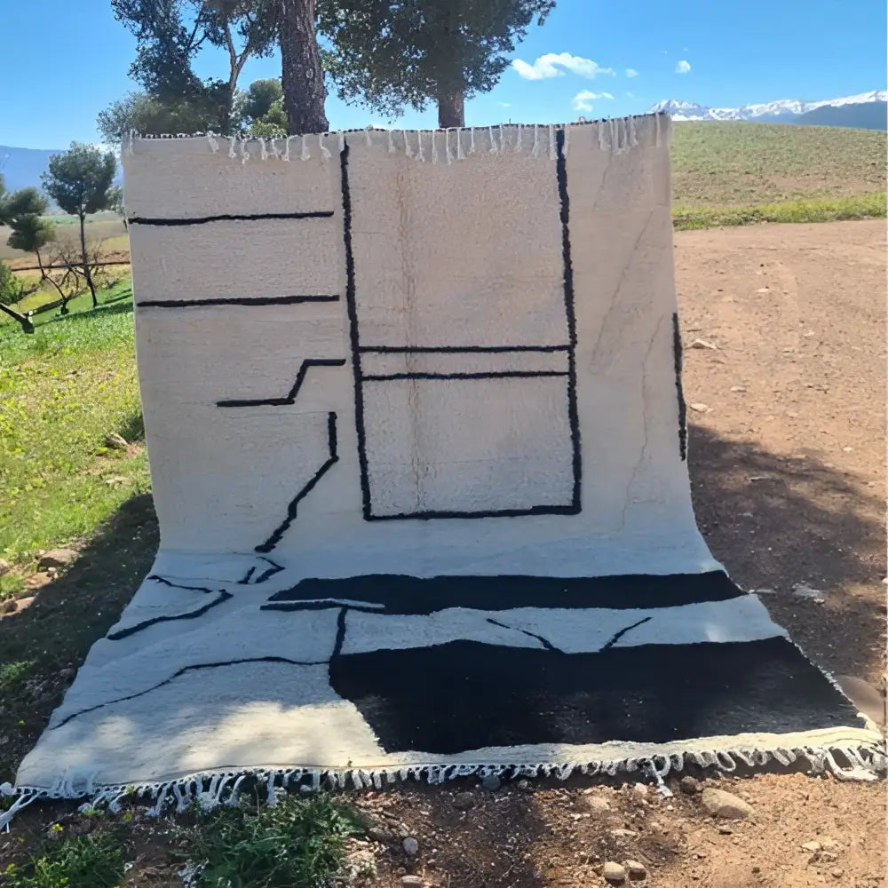 Cream-colored decorbites™ moroccan handmade beni ouarain rug with bold black geometric patterns and fringed edges 3m x 2m