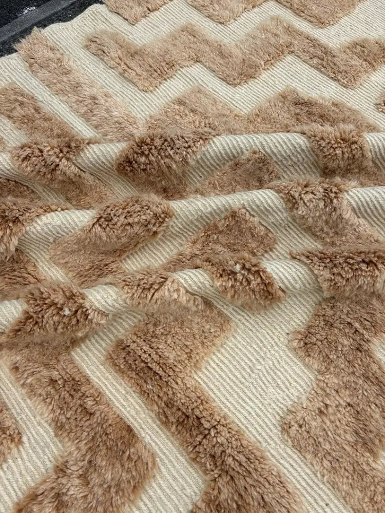 A plush beige and tan chevron-patterned moroccan handmade beni ouarain rug with a textured fuzzy surface 3m x 2m