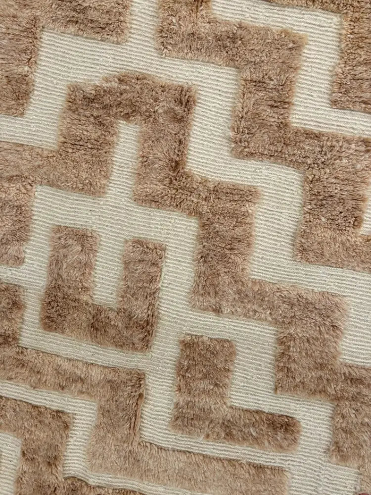 A moroccan handmade beni ouarain rug 3m x 2m with beige and tan geometric patterns and a plush textured shaggy surface