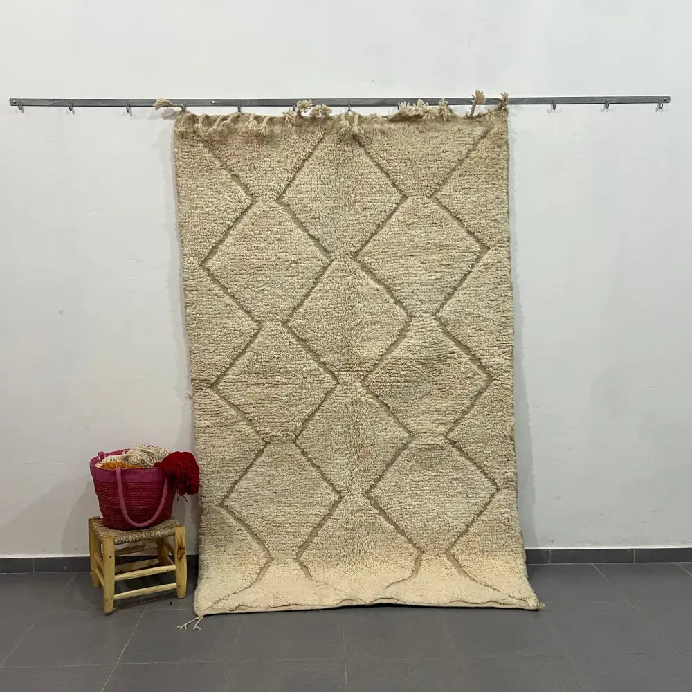 Beige moroccan handmade carpet with textured diamond pattern and fringed edges by skilled artisans for floor covering