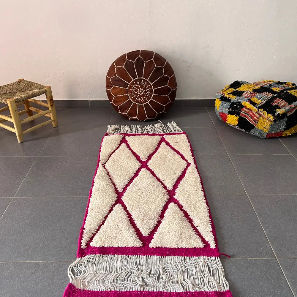 Cream and magenta geometric-patterned moroccan handmade beni ouarain rug with fringed edges by DecorBites