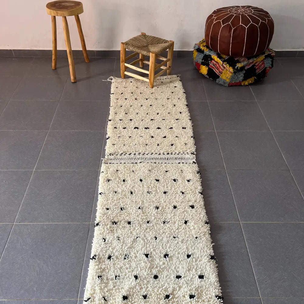 A cream-colored textured moroccan handmade beni ouarain rug with black dot pattern by decorbites in 1m x 70cm size