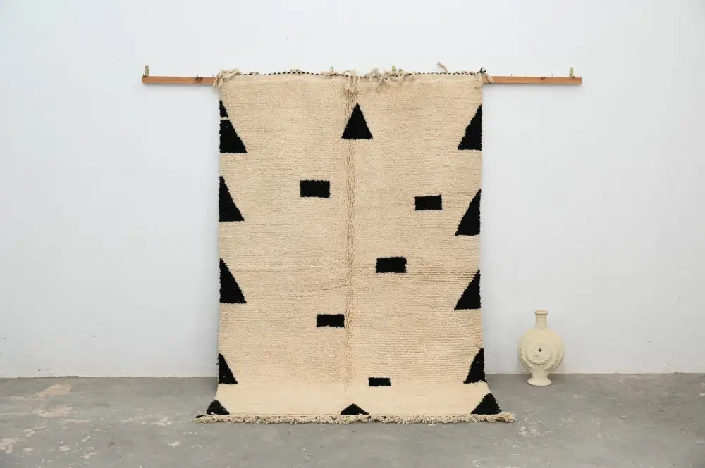 Beige moroccan handmade traditional azilal rug with black geometric triangle and rectangle patterns and fringed edges