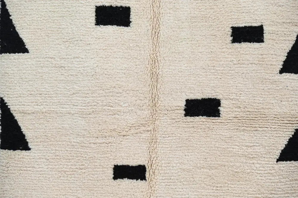 Cream-colored wool moroccan handmade traditional azilal rug with bold black geometric shapes 224 x 152 cm