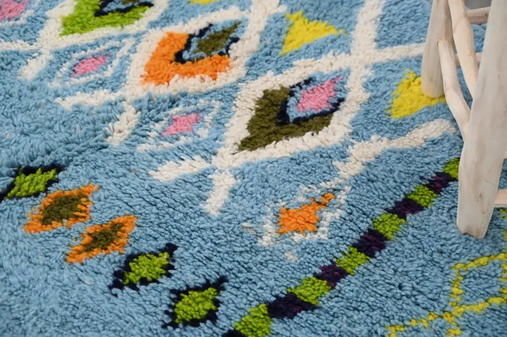 A plush light blue moroccan handmade traditional azilal rug with vibrant geometric patterns by DecorBites