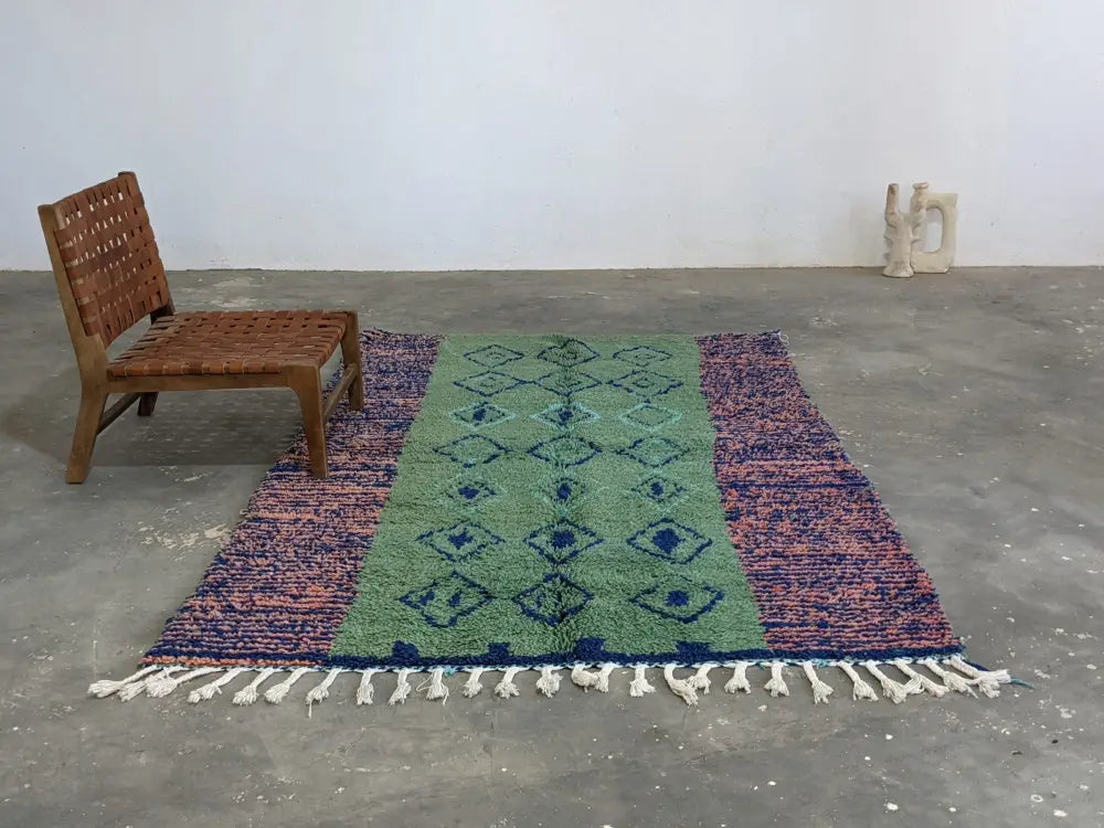 A moroccan handmade azilal rug in pure natural wool with green central field and blue geometric patterns