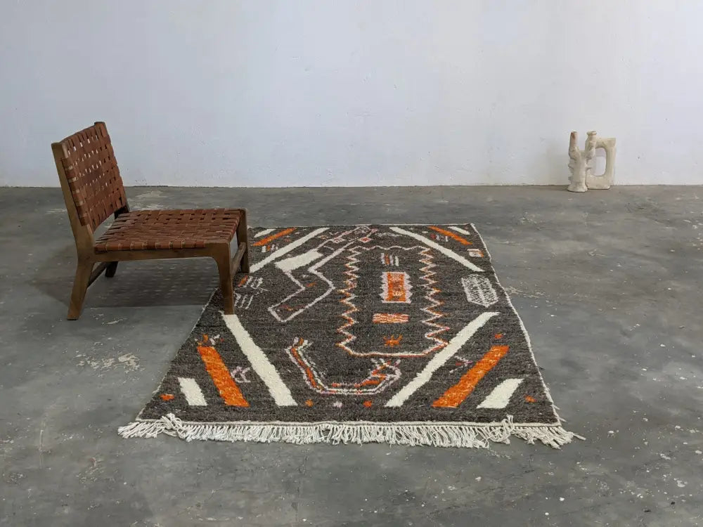 Decorbites moroccan handmade azilal rug in dark gray with bold orange and white geometric patterns made of pure natural wool