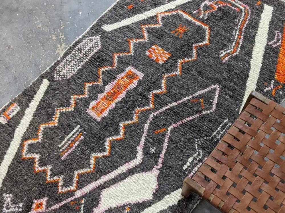 DecorBites™ moroccan handmade azilal rug in dark gray with intricate orange white and pink patterns in pure natural wool