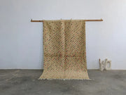 Beige moroccan handmade azilal rug in pure natural wool with red and black diamond motifs and fringed edges by DecorBites