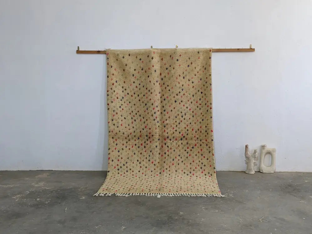 Beige moroccan handmade azilal rug in pure natural wool with red and black diamond motifs and fringed edges by DecorBites