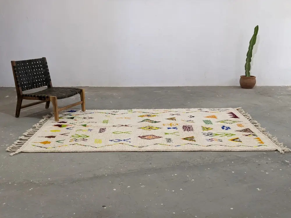 Beige moroccan handmade traditional azilal rug with colorful geometric patterns and fringed edges by decorbites