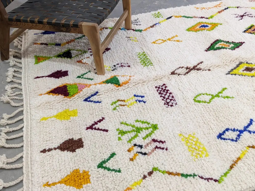 Cream-colored moroccan handmade traditional azilal rug with fluffy texture and vibrant multicolored geometric patterns