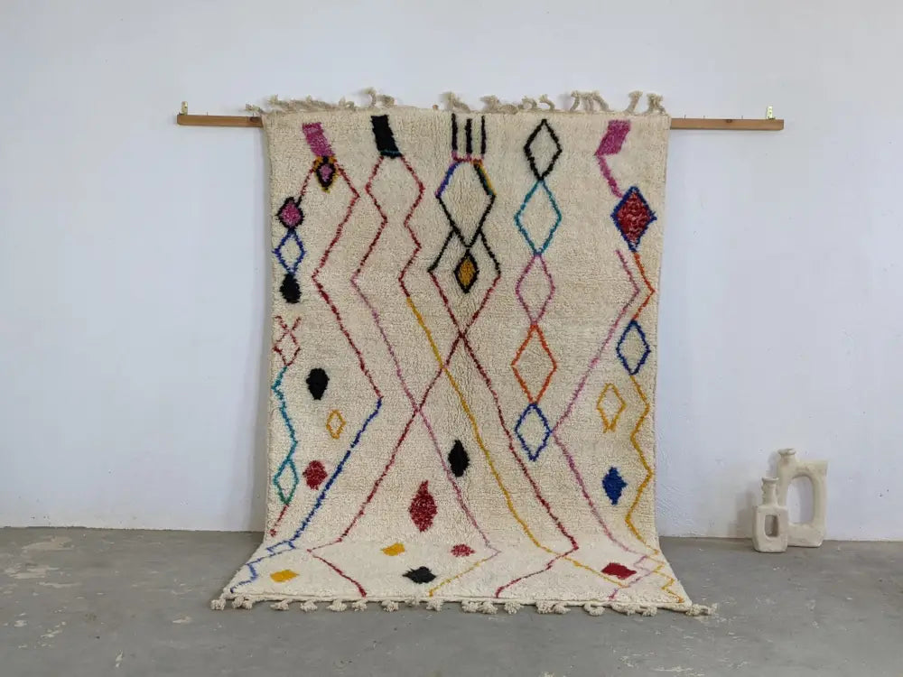 Cream-colored moroccan handmade traditional azilal rug with vibrant pink black blue yellow and red geometric patterns 252 x 160 cm