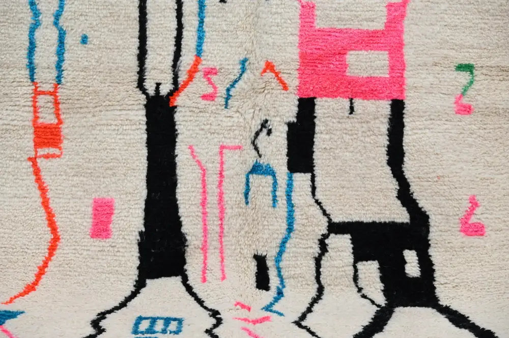 Decorbites™ moroccan handmade traditional azilal rug with bold black silhouettes and colorful geometric patterns on cream wool