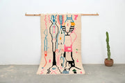 Beige woven decorbites™ moroccan handmade traditional azilal rug with vibrant pink, blue, black, and orange geometric patterns