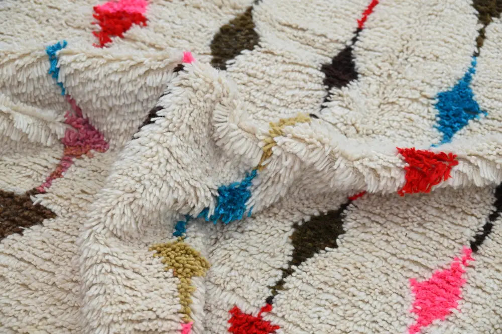 Cream-colored moroccan handmade traditional azilal rug with plush shaggy texture and bold geometric patterns by DecorBites