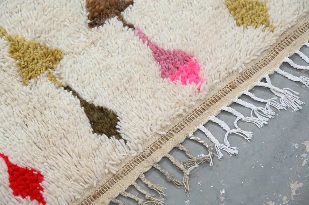 Cream-colored moroccan handmade traditional azilal rug with fluffy texture and geometric patterns in multiple colors