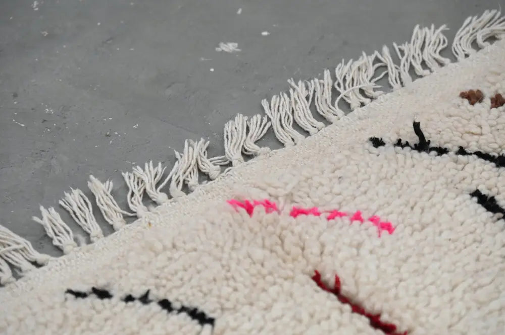 DecorBites™ moroccan handmade traditional azilal rug in cream with fluffy white fringe and bold black red pink embroidery