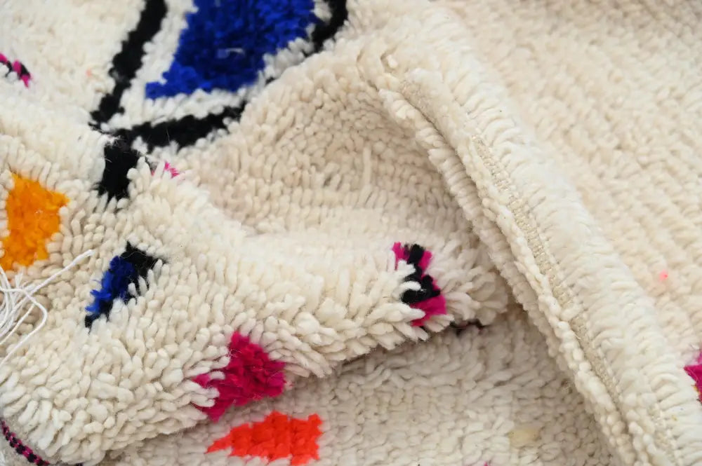 Cream-colored moroccan handmade traditional azilal rug with bold blue black orange and pink geometric patterns 260 x 148 cm
