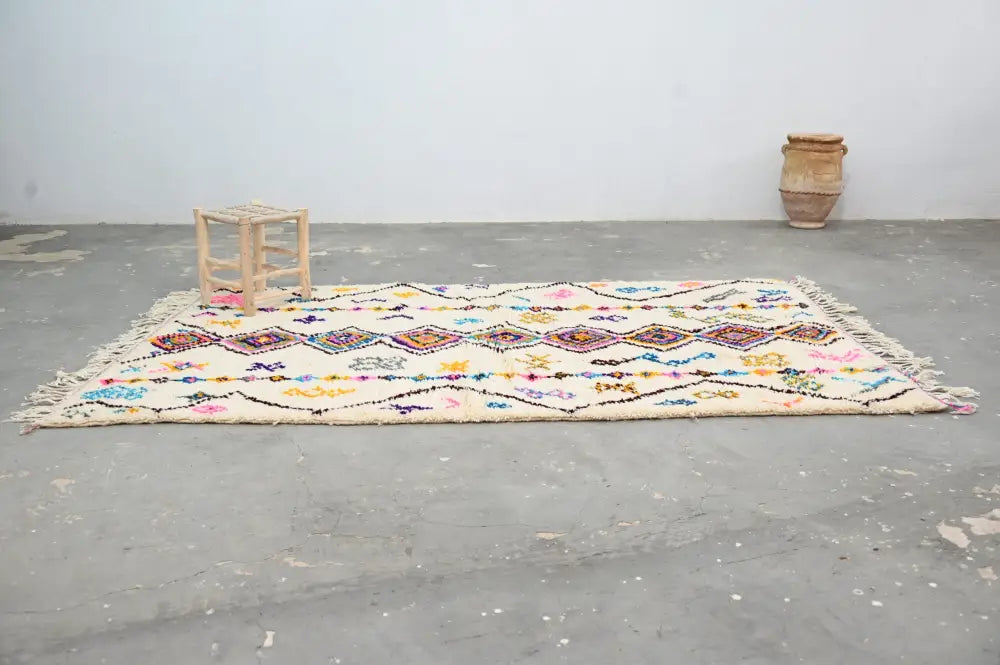 Beige moroccan handmade traditional azilal rug with colorful geometric patterns and fringed edges by decorbites