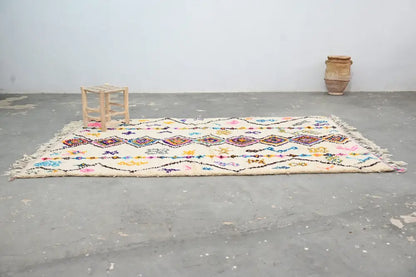 Beige moroccan handmade traditional azilal rug with colorful geometric patterns and fringed edges by decorbites