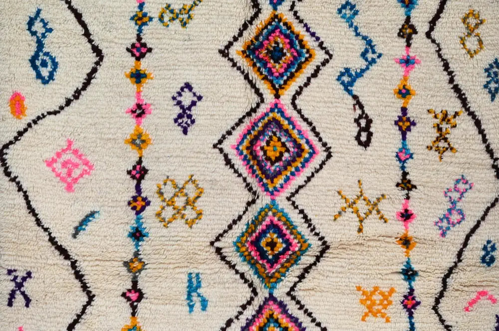 DecorBites™ moroccan handmade traditional azilal rug in cream with bold pink blue purple orange geometric patterns and black outlining
