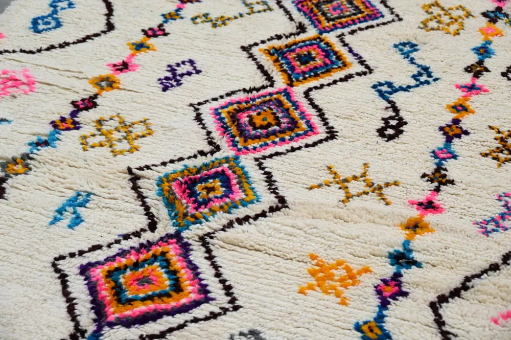 Cream-colored DecorBites™ moroccan handmade traditional azilal rug with vibrant pink blue yellow and purple geometric patterns