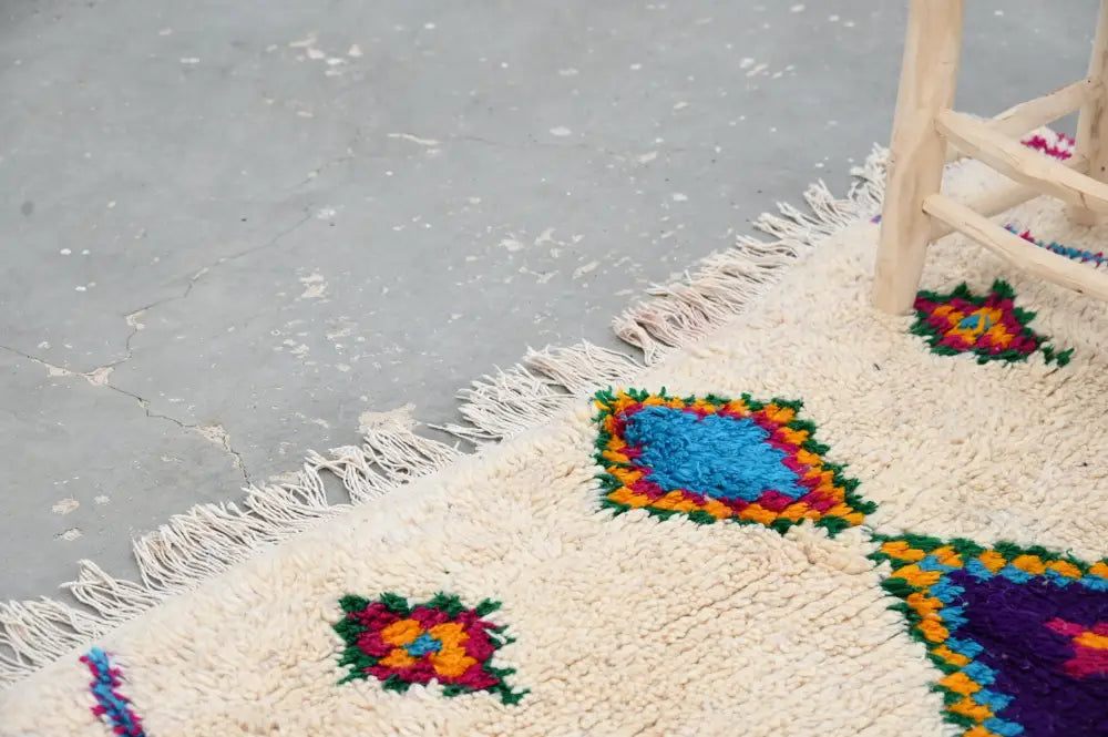 Cream-colored DecorBites™ moroccan handmade traditional Azilal rug with vibrant geometric patterns and long white fringe