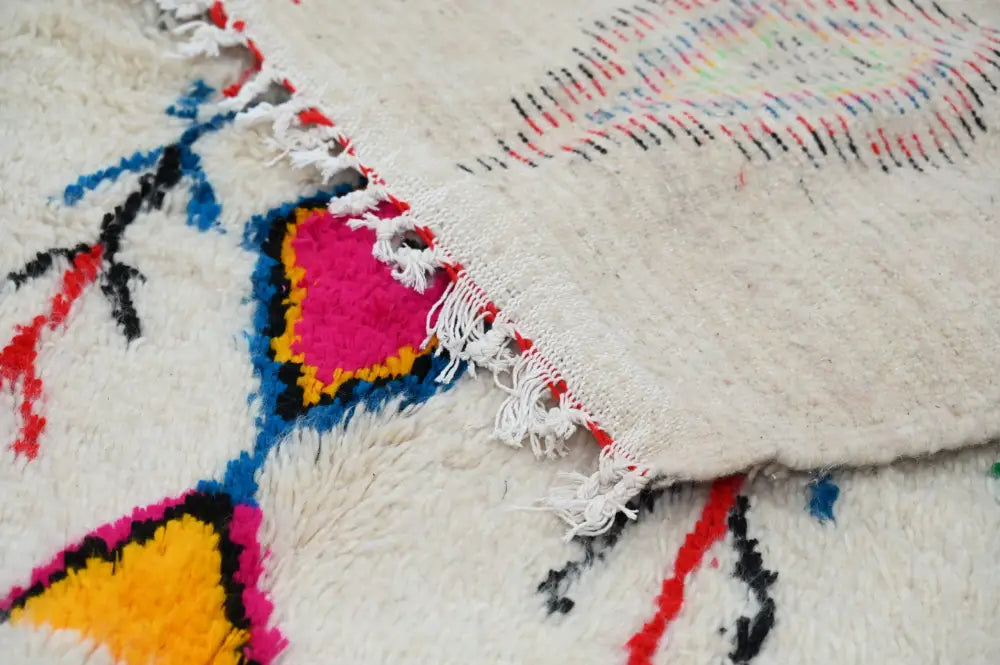 DecorBites™ moroccan handmade traditional azilal rug with a cream base and bold pink yellow blue black geometric patterns