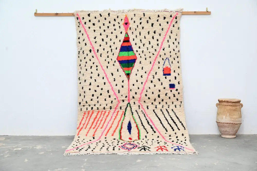 A vibrant moroccan handmade traditional azilal rug by decorbites with cream base and bold pink black green blue red patterns