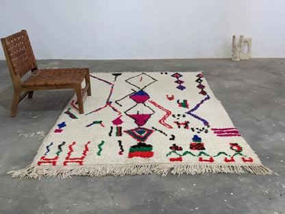 Cream-colored moroccan handmade azilal rug with vibrant geometric patterns in pure natural wool and fringed edges