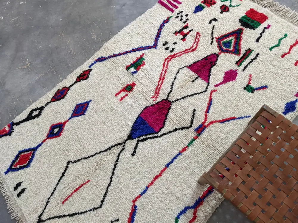 Cream-colored moroccan handmade azilal rug with vibrant geometric patterns on pure natural wool textured base