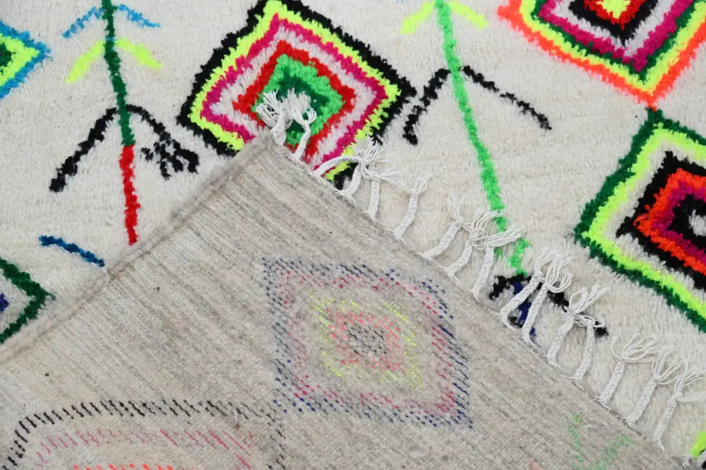 Vibrant moroccan handmade traditional azilal rug featuring colorful geometric squares on cream wool with fringed edges