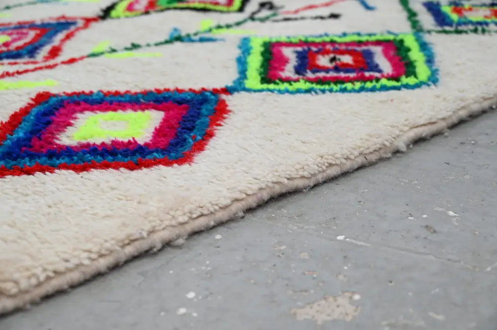Vibrant moroccan handmade traditional azilal rug with geometric pattern wool in red blue pink and neon green on cream base