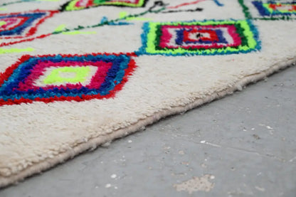Vibrant moroccan handmade traditional azilal rug with geometric pattern wool in red blue pink and neon green on cream base