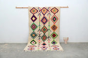 Beige moroccan handmade traditional azilal rug with vibrant red green blue and yellow geometric patterns 267 x 150 cm