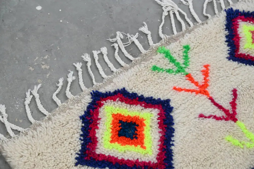 Cream-colored decorbites™ moroccan handmade traditional azilal rug with bold geometric patterns and white fringe