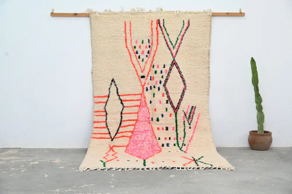 Beige moroccan handmade traditional azilal rug with vibrant pink green red and black geometric patterns by decorbites